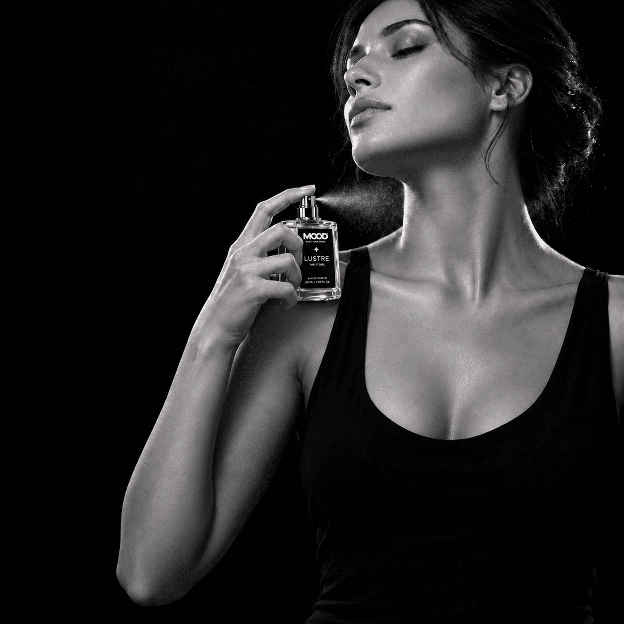 Lustre bottle in hand — monochrome portrait with pink perfume.